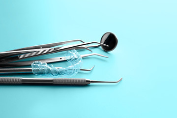 Dental instruments and occlusal splint on color background