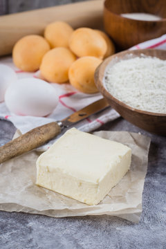Baking ingredients for cake, pie, shortbread pastry: flour, eggs, sugar, butter, rolling pin and on gray concrete table background. Top view, copy space