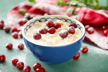Tasty oatmeal with cherries in bowl on table