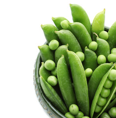 Bowl with green peas on white background