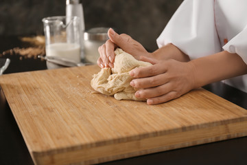 Chef kneading dough for bakery on kitchen table