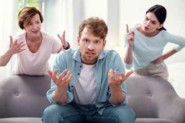 Difficult family situation. Depressed cheerless man feeling stressed while listening to the quarrel...