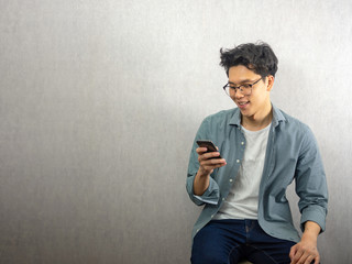 Asian man using phone, happy and smile looking at the screen