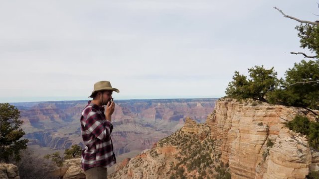 Man Tourist Talking On The Radio Traveling The Grand Canyon