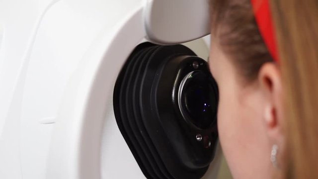 Close up shot of young girl is getting her eyes examined in a hospital. Checking on her cornea using professional equipment.