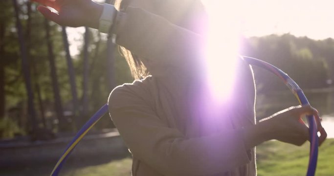 Woman spinning holla hoop over head laughing - slow motion