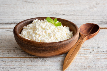 Ricotta cheese, curd cheese, farmers cheese or tvorog in wooden bowl. Selective focus. Concept of healthy eating, healthy lifestyle and dieting