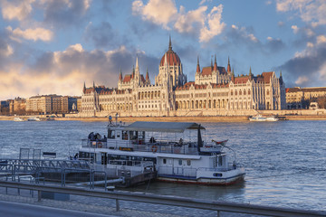 Fototapeta premium view of the tourist ship on the Danube against the Parliament building and the beautiful evening sky