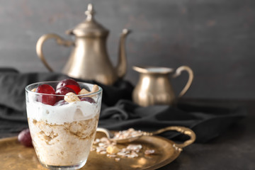 Tray with tasty oatmeal dessert in glass on table