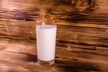 Full glass of milk on a wooden table