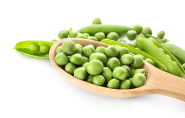 Spoon with green peas on white background