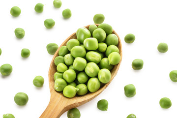 Spoon with green peas on white background