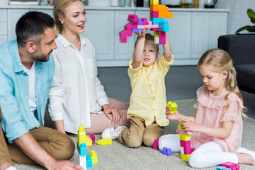 happy family playing with colorful blocks at home