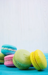 Delicious colorful macaron cakes on wooden background