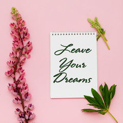 Composition with flowers and notebook on pink background. Flat lay. Inspiration Leave You Dreams.
