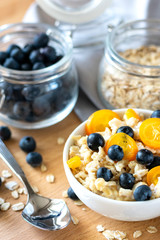 healthy breakfast: oatmeal porridge with blueberries and kumquat, next to a glass jar of blueberries and oatmeal. the concept of diet and healthy lifestyle