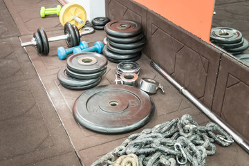 Weights for rod and dumbbells. large steel chain on the floor in the gym