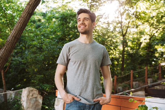 Pictire of Smiling brunette man in casual clothes looking away