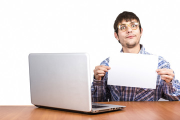 cheerful guy in glasses sits at table with computer computer on white background