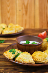 Delicious baked empanadas on wooden background