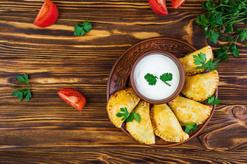 Delicious baked empanadas on wooden background