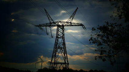 High-voltage poles on a background of a cloudy sunset. The power of energy. Power line.