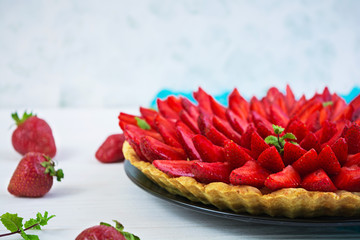 Delicious tart with strawberry on wooden background