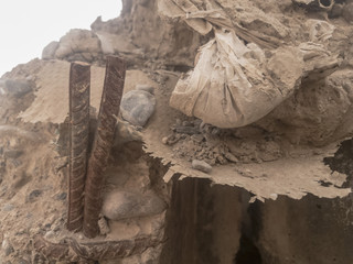 Crumbling cement bag on top of t-wall with exposed rebar