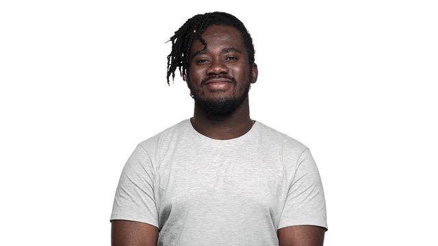 Portrait of seductive flirty man with stylish afro hairdo and mustache blowing air kiss to you, isolated over white background slow motion. Concept of emotions