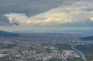 View from airplane window earth ground river and clouds travel tourism Istambul Turkey. Wing of an airplane flying above the clouds over ground cloudy stormy sky.