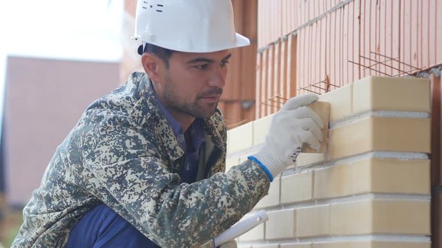 Builder aligns the seams when laying bricks