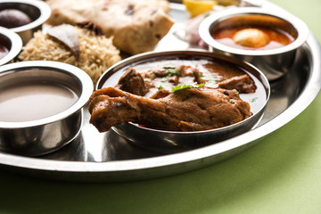 Kolhapuri chicken Thali is a popular Indian/asian food platter consists of poultry meat, egg curry with chapati ,rice, salad and sweet Gulab Jamun