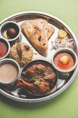 Kolhapuri chicken Thali is a popular Indian/asian food platter consists of poultry meat, egg curry with chapati ,rice, salad and sweet Gulab Jamun