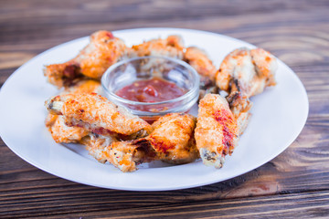 fried chicken wings on a plate with tomato sauce