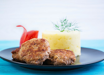 Puree potatoes with cutlets on wooden background
