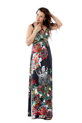 young beautiful woman in sundress with colorful flower pattern straightens his hair, looking at camera, full body portrait