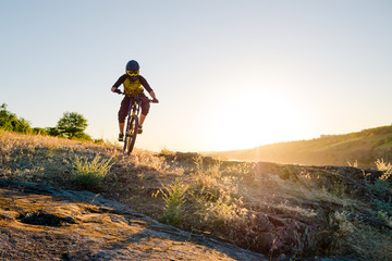 Fototapeta premium Cyclist Riding the Mountain Bike on the Summer Rocky Trail at the Evening. Extreme Sport and Enduro Cycling Concept.