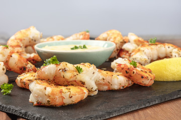 A closeup photo of plate of cooked shrimps with a sauce and copy space