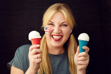 Girl with the American flag on her face eating ice cream.