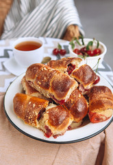 Homemade baked croissant with fresh garden cherries