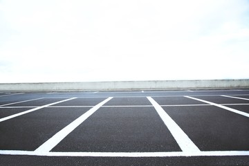 Empty outdoor parking lot space marked with white lines. Can accommodate car a lot. © methaphum
