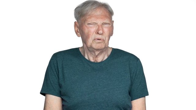 Portrait of adult man 80s grimacing at camera with disgusting emotions and expressing aversion slow motion, isolated over white background