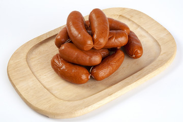 Boiled sausages on a wooden tray.