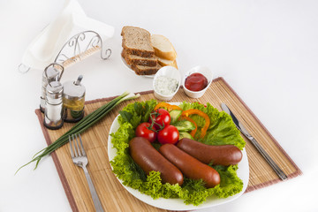 Boiled sausages with tomatoes, cucumbers and greens. Served with black or white bread.