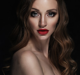 Blonde fashion girl with long and shiny curly hair. Red lips and bright make up.