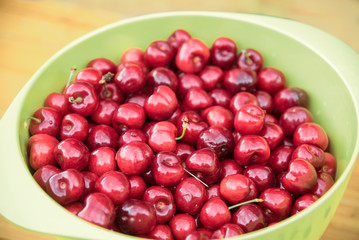 red cherries in a green bowl, healthy organic fruits freshly harvested from the orchard