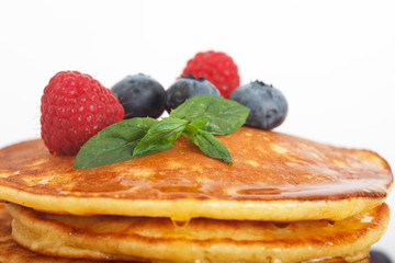 Closeup of Delicious sweet American pancakes with fresh fruits and addons. White background