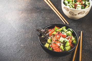 Asian trendy food, sushi poke bowl with cucumber, salmon, avocado, Black and White Sesame Seeds