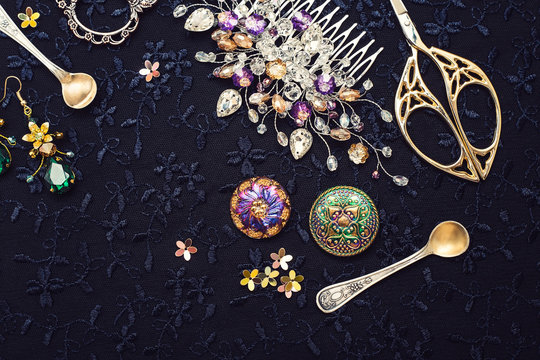 Beautiful hair accessories, scissors and buttons on a dark background. Different handmade instruments. Comb for the hair.