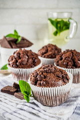 Home baked mint and chocolate muffins with mint tea, white marble background copy space